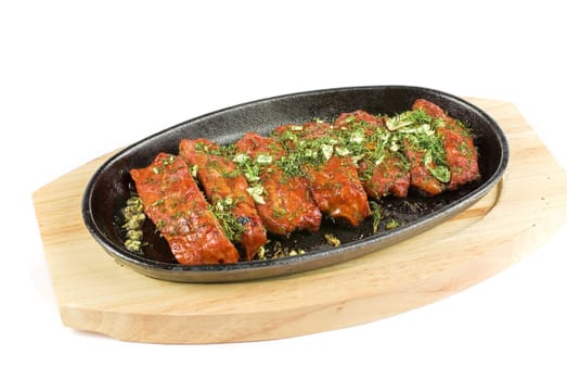 Spare ribs and greens closeup for dinner at pan isolated on a white