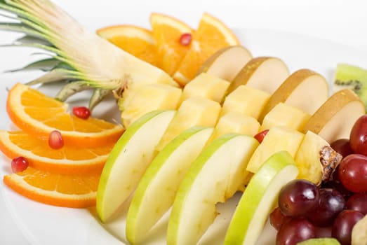Fruit assortment closeup at plate on a white background