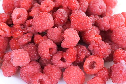 frame full with fresh raspberries on a white