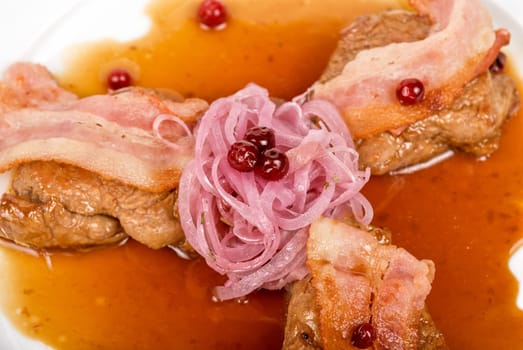 Roast pork meat with bacon, onion and cranberries
