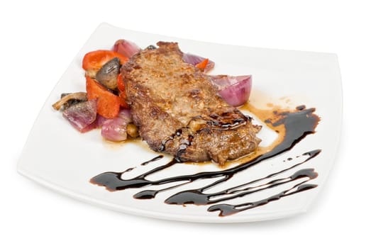 Roasted beef steak with vegetable closeup at plate