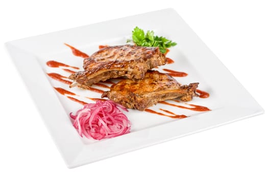 Roasted pork meat at plate with greens