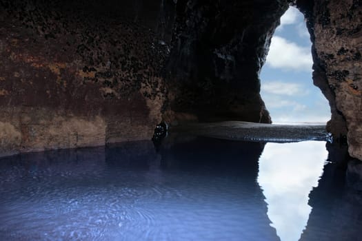 a view from the inside of a beach cave looking out at the sea