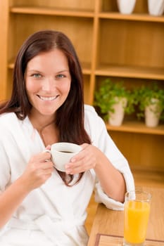 Breakfast - Smiling woman with cup of coffee in modern interior