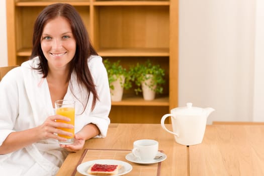 Breakfast orange juice and toast happy woman in home bathrobe