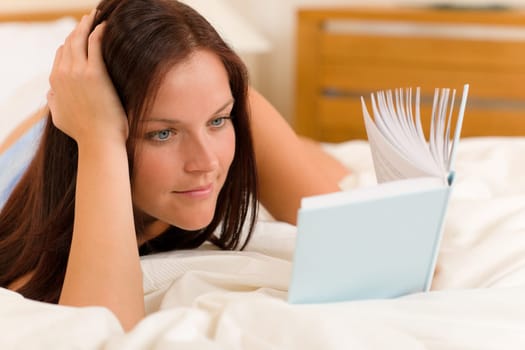 Bedroom - young woman read book in white bed