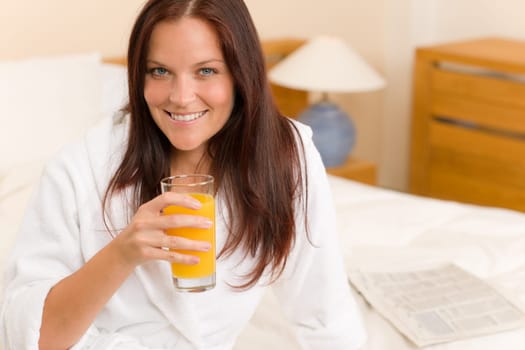 Breakfast - Smiling woman with fresh orange juice in white bedroom