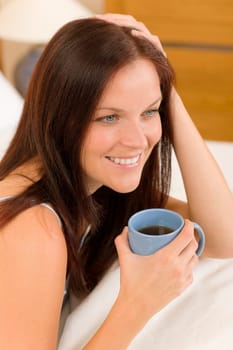Bedroom - young woman drink coffee lying in white bed