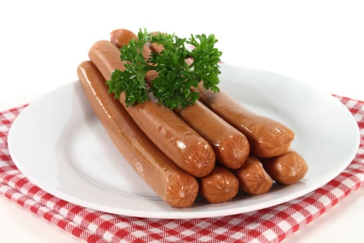 Viennese sausages and parsley on a white plate