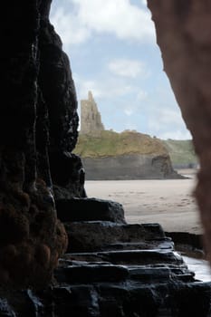 a view of ballybunion castle as seen from a cliff cave