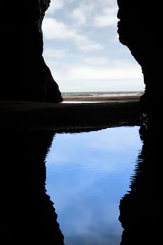 a view from the inside of a beach cave looking out at the sea