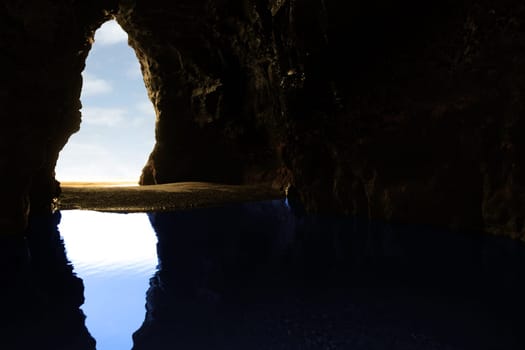 a view from the inside of a beach cave looking out at the sea