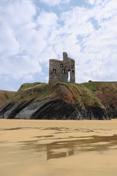 the old ruin of a castle in ballybunion overlooking the beach