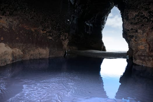 a view from the inside of a beach cave looking out at the sea