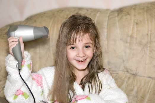 The little girl dries hair after bathing