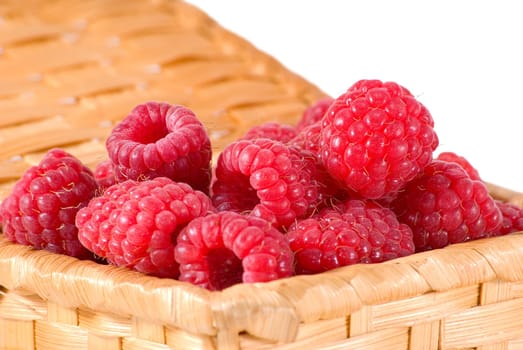 The bast-basket with a raspberry is photographed on a white background