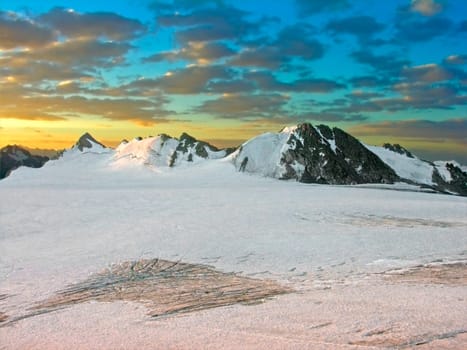 The snow-covered mountains lighted by a sunset
