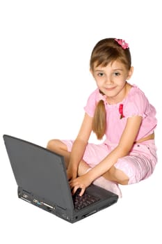 The girl in pink clothes sits with a notebook computer