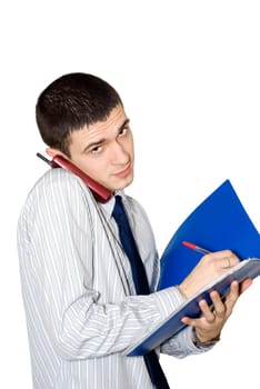 The young man writes and simultaneously speaks by phone