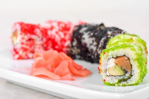 Sushi rolls made of fish avocado and different flying fish roe (tobiko caviar)