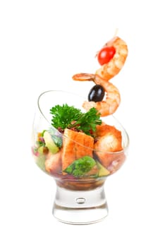Fried kebab of shrimps with vegetables, greens and salmon fish