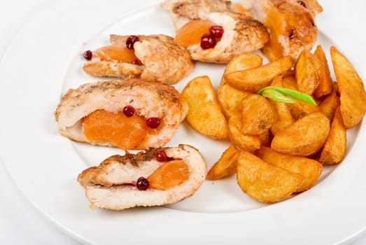 Roast chicken meat with apricot and potato closeup