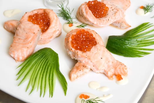 roasted salmon filet with red caviar, cucumbers and sauce