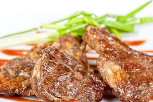 Roasted lamb meat tied with scallion closeup