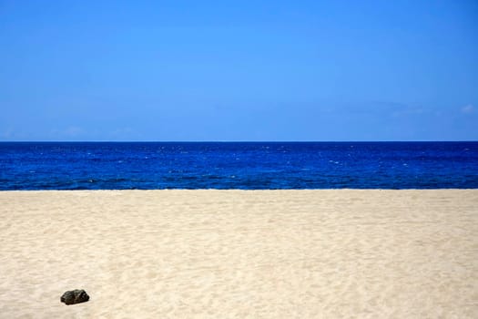 Sandy beach with blue sea and sky in landscape format