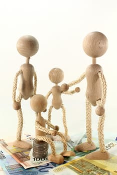 a family of wooden dolls and euro bills