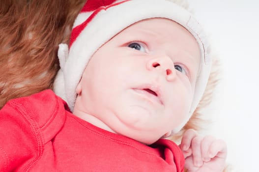 Newborn baby in chritstmas hat lies on fur