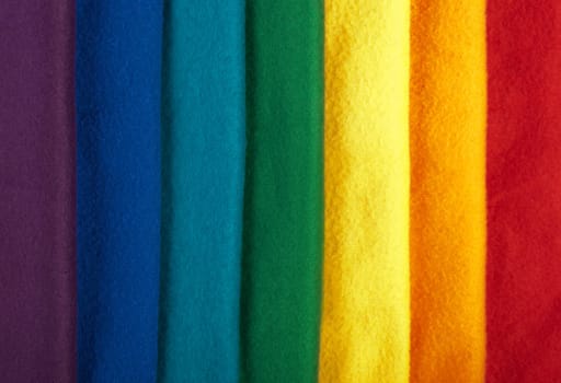 Rainbow background made of colorful winter scarfs