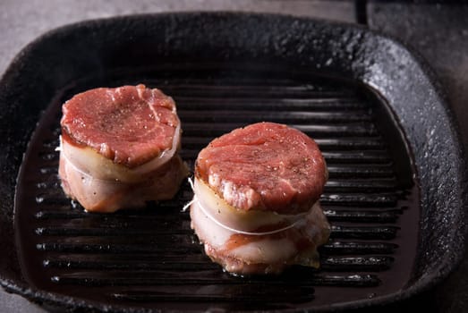 Tasty beef steak grilling in a cast-iron ribbed fry pan