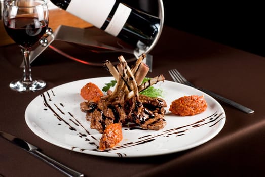 Roasted lamb chops with vegetables on decorated table