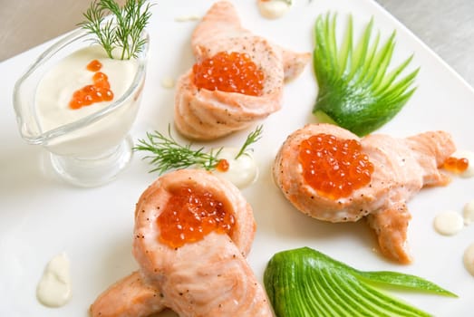 roasted salmon filet with red caviar, cucumbers and sauce