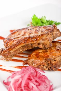 Roasted pork meat at plate with greens
