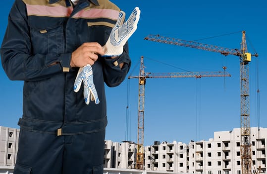 Closeup worker with gloves over building background