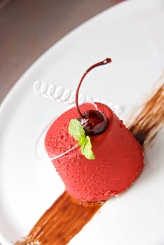 Tasty dessert of whipped cream, chocolate cherry, caramel and mint