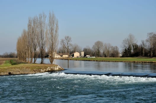 foreshortening of important artificial canal in winter country , shot in bright light on lombardy plains