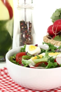 a white bowl of mixed salad