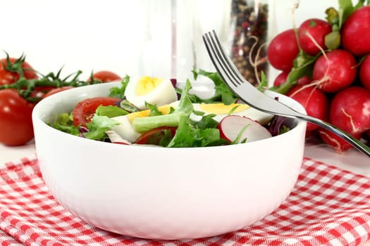 a white bowl of mixed salad