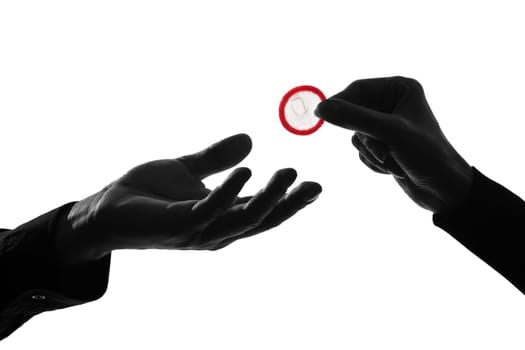 one caucasian couple man and woman hands holding tossing offering giving condom  in studio silhouette isolated on white background