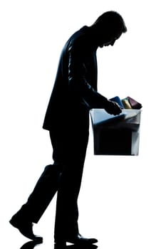 one caucasian man walking  full length fired carrying heavy box silhouette in studio isolated white background