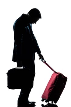 side view one caucasian business traveler man tired with suitcase  full length silhouette in studio isolated white background