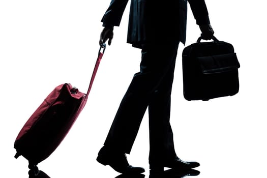 detail side view one caucasian business traveler man walking with suitcase  full length silhouette in studio isolated white background