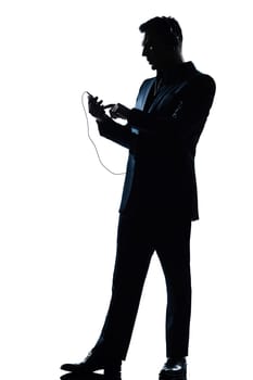 one caucasian man text messaging telephone listening to music full length silhouette in studio isolated white background