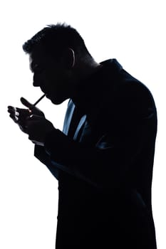one caucasian man portrait smoking lighting cigarette silhouette in studio isolated white background