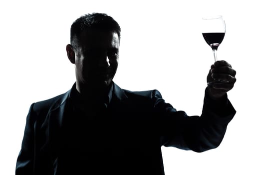 one caucasian man portrait silhouette rising up toasting his glass of red wine in studio isolated white background
