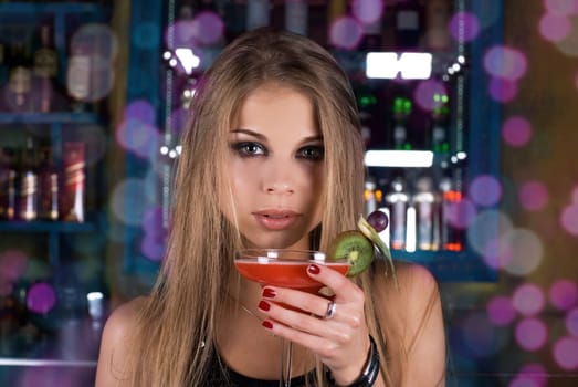Girl with cocktail on dancing people background