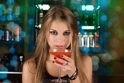 Girl with cocktail on dancing people background